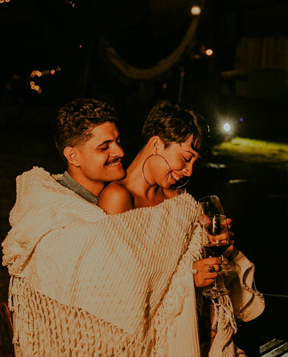 Casal abraçado brindando com vinho no Container Du Lago